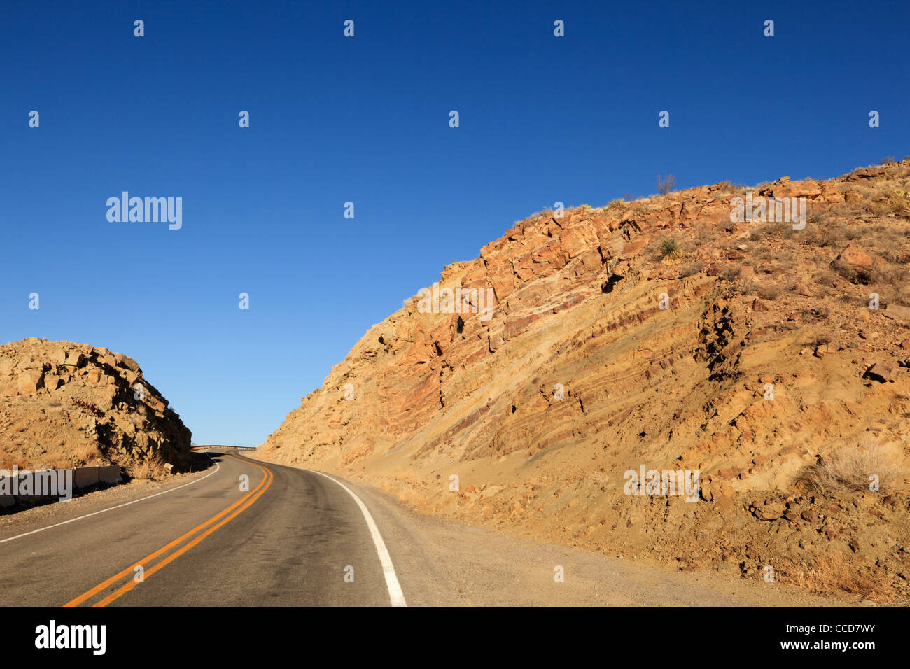 Autostrada rurale in esecuzione attraverso terreni accidentati vicino a Elephant Butte nel Nuovo Messico, Stati Uniti d'America. Foto Stock