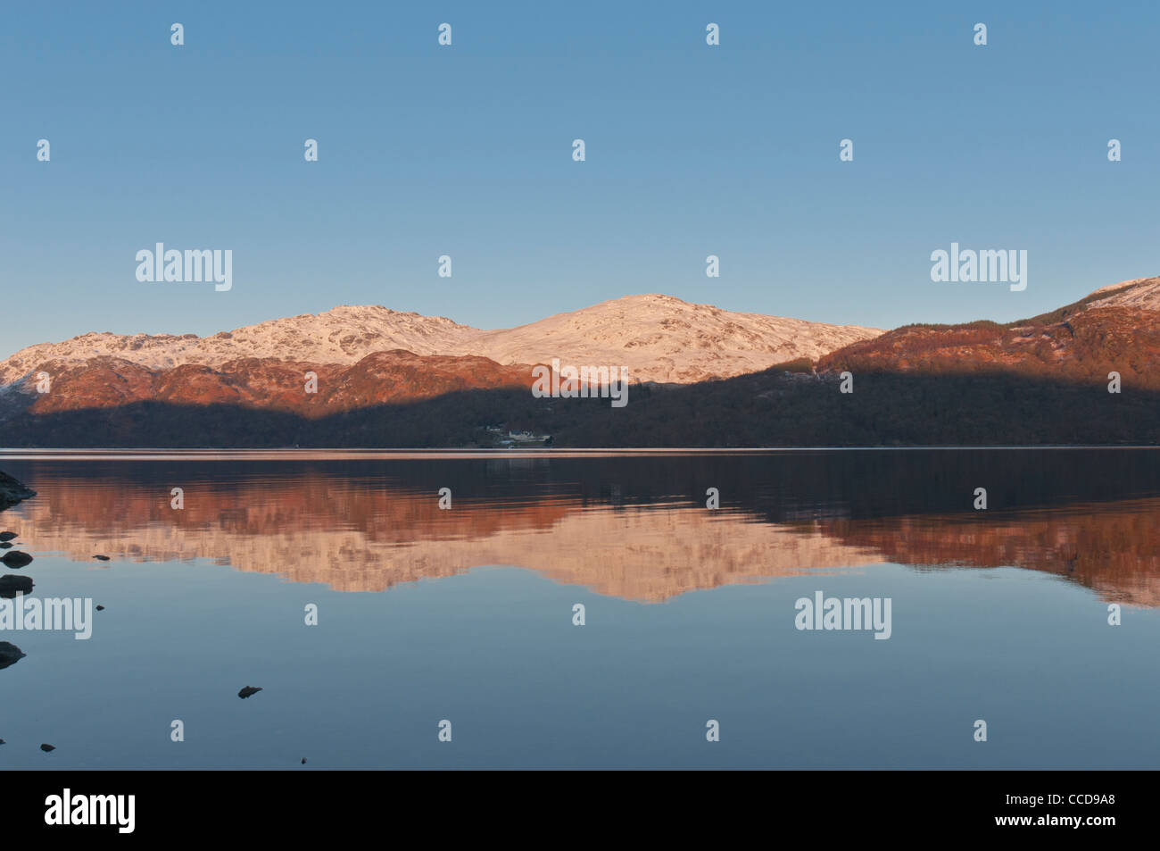 Riflessi di neve e sole di setting Loch Lomond cercando di Inversnaid Argyll & Bute Scozia Scotland Foto Stock