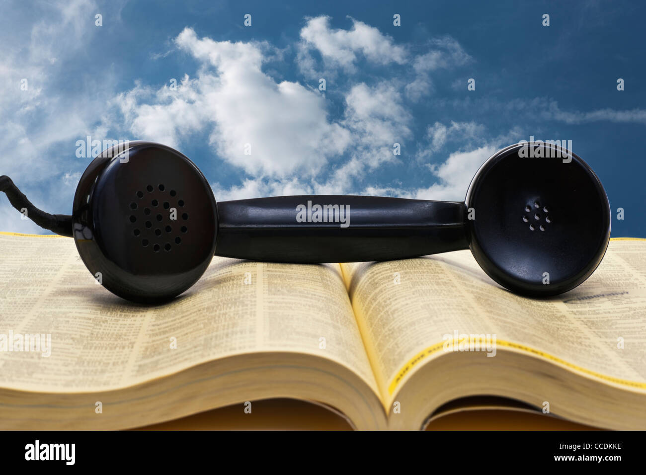 Dettaglio foto di un vecchio ricevitore telefonico, giacente su una rubrica telefonica Foto Stock