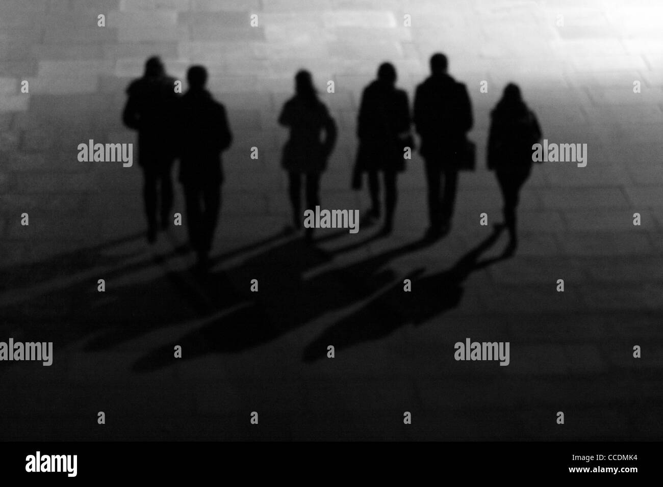 Un leggermente fuori fuoco colpo di un gruppo di persone in silhouette, a piedi di notte Foto Stock