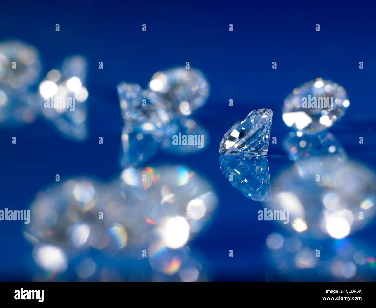 Un gruppo di diamanti su un blu sfondo riflettente Foto Stock