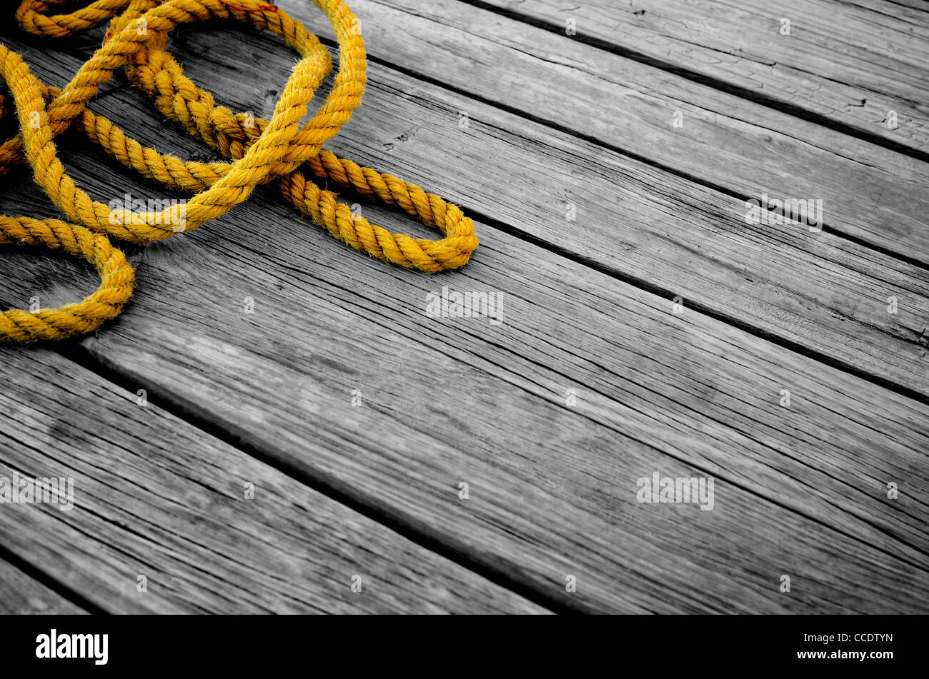 Curly fune sul molo in legno. Grungy composizione di sfondo con selezionare il colore. Foto Stock