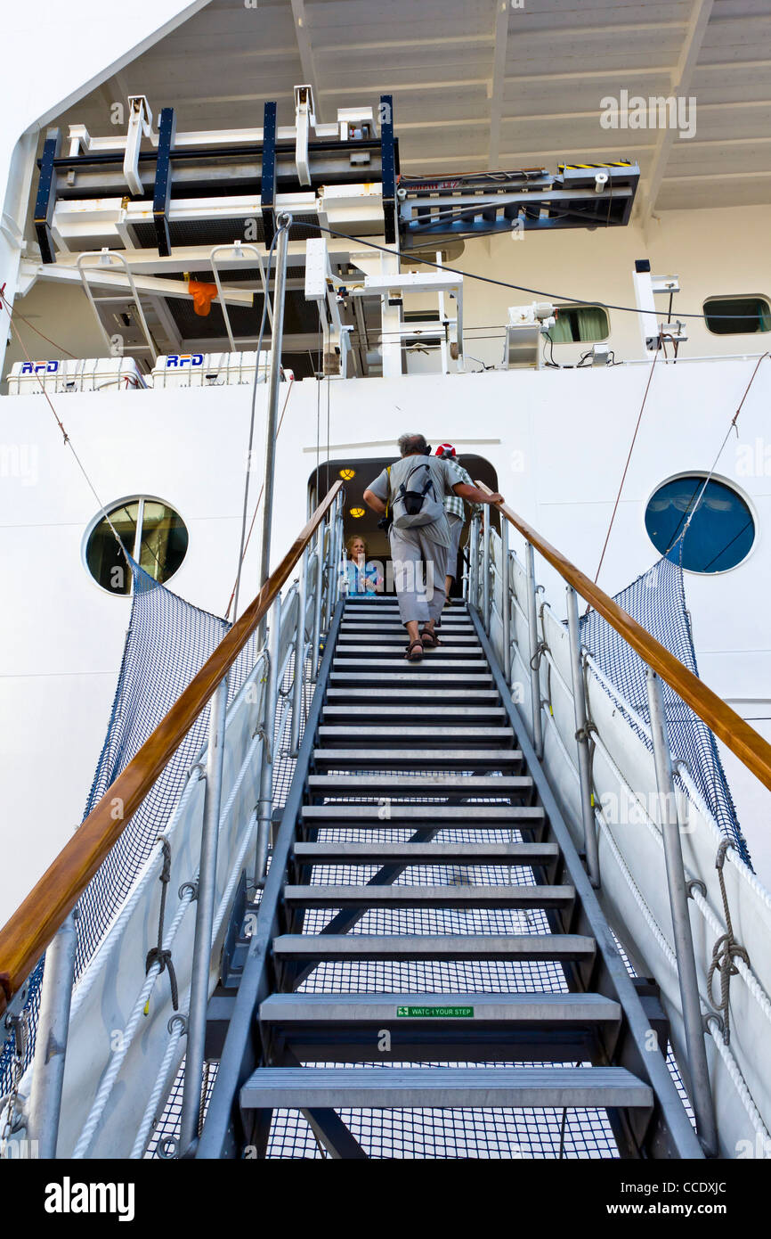 Signora anziana utilizzando la passerella le scale per salire a bordo della nave da crociera MSC Armonia Foto Stock