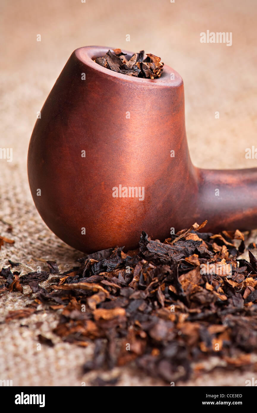 Macro di tubo di fumo e tabacco sulla tela di lino sfondo Foto Stock