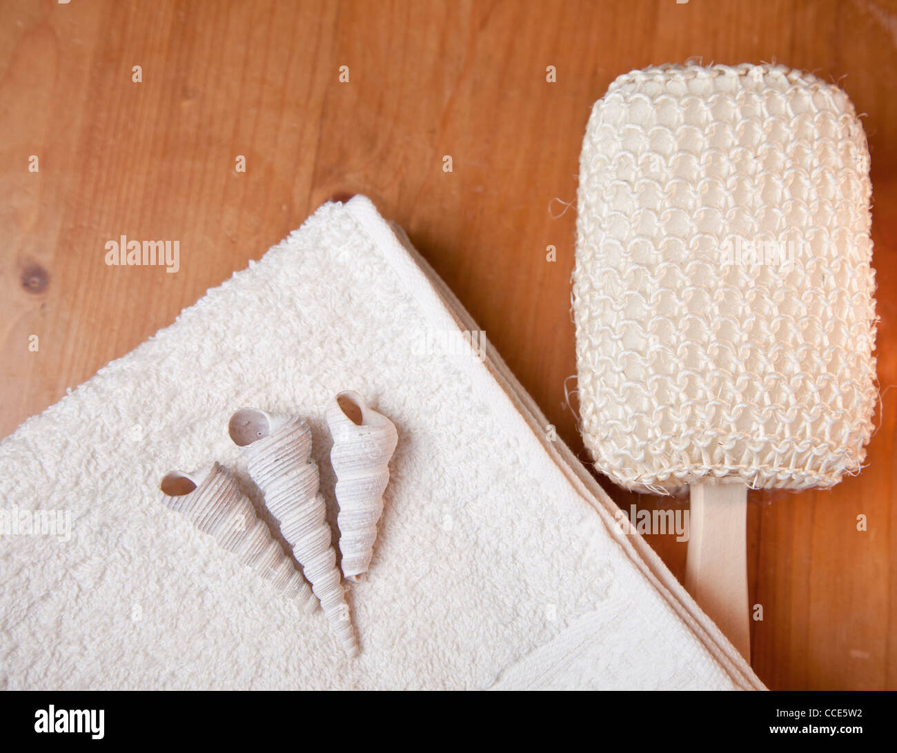 Lussuosi bagni con vasca o doccia con asciugamano, spazzola e gusci sul tavolo di legno Foto Stock