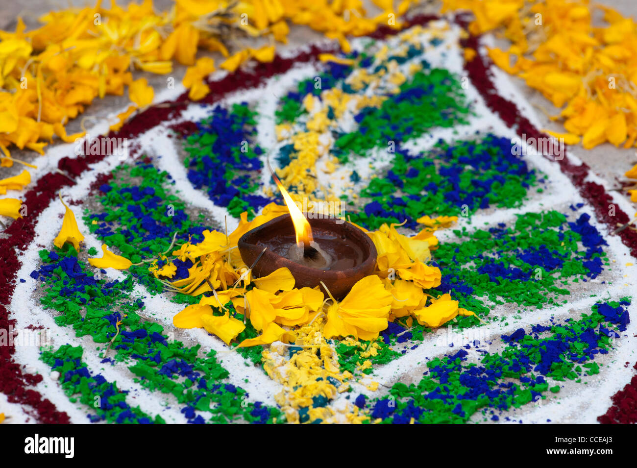 Rangoli festival di polvere colorata lamine con petali di fiori e una lampada ad olio. India Foto Stock