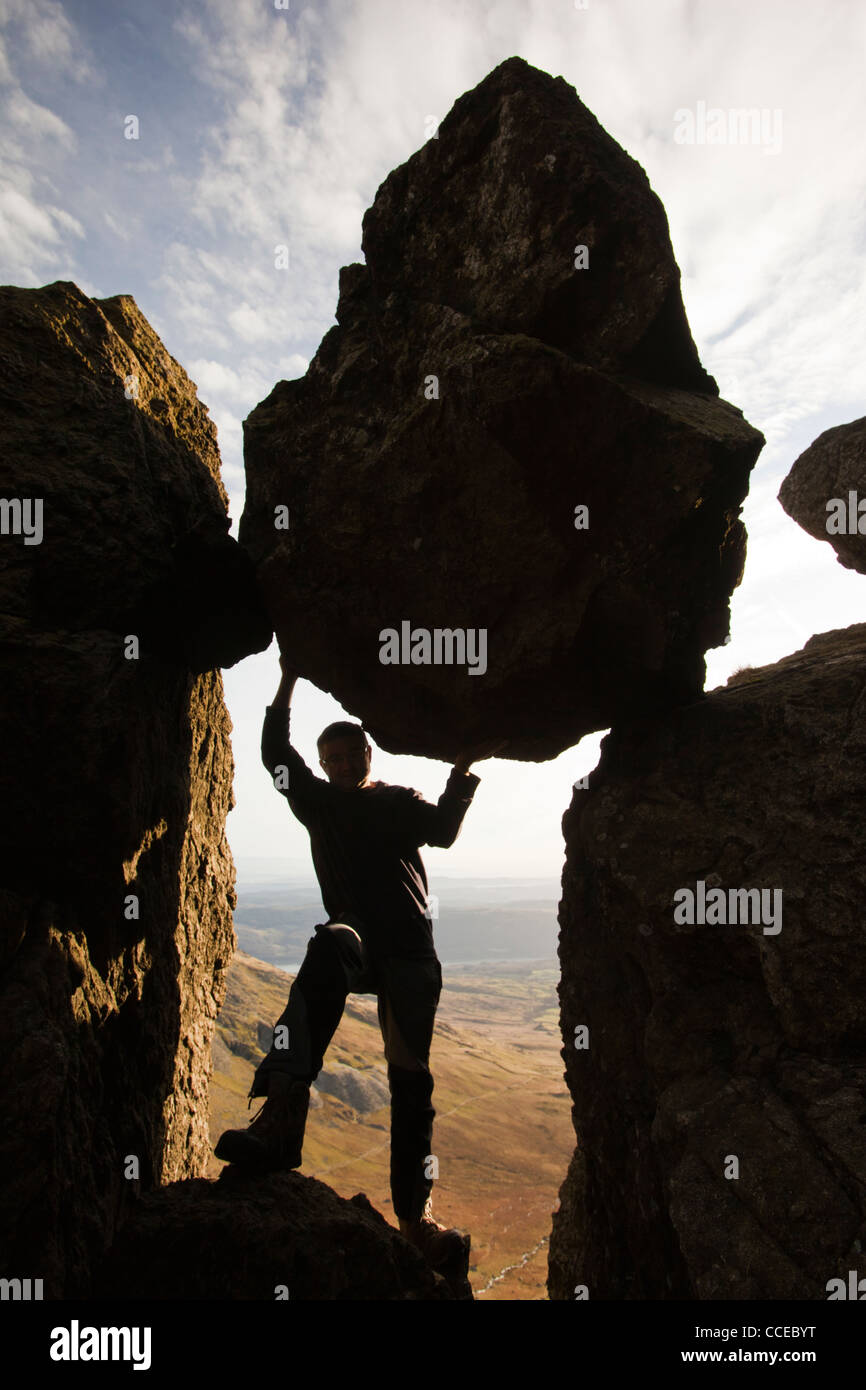 Un scalatore fingendo di tenere un cuneo la pietra in un burrone su Dow Crag nel distretto del lago, UK. Foto Stock