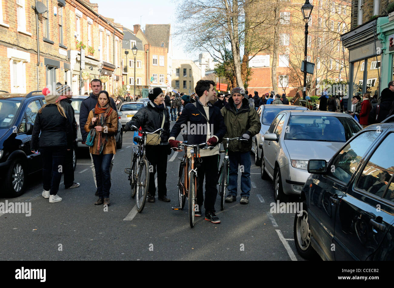 I ciclisti spingendo le loro biciclette in Columbia Road Flower Market Tower Hamlets London Inghilterra England Regno Unito Foto Stock