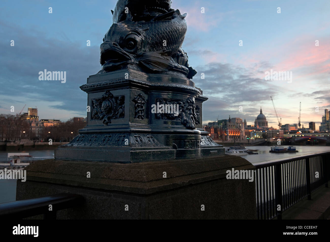 Queen's Walk, South Bank di Londra SE 1 con ghisa scultura di pesce e dello skyline della città tra cui la Cattedrale di St Paul Foto Stock