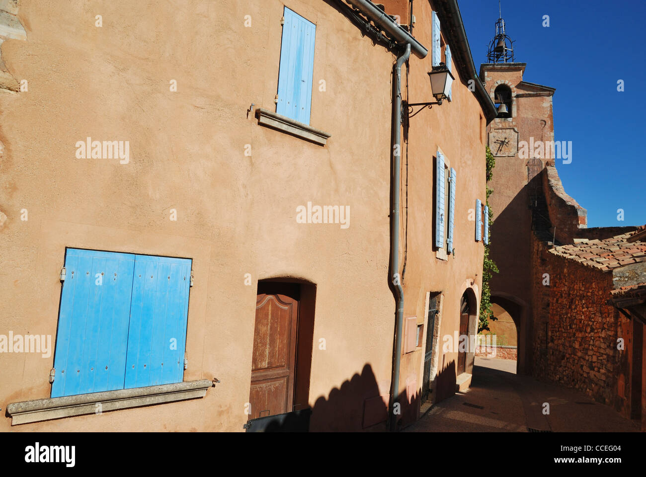 Ocra-case colorate e la torre dell orologio nel villaggio di collina di Roussillon Vaucluse Provence, Francia. Foto Stock