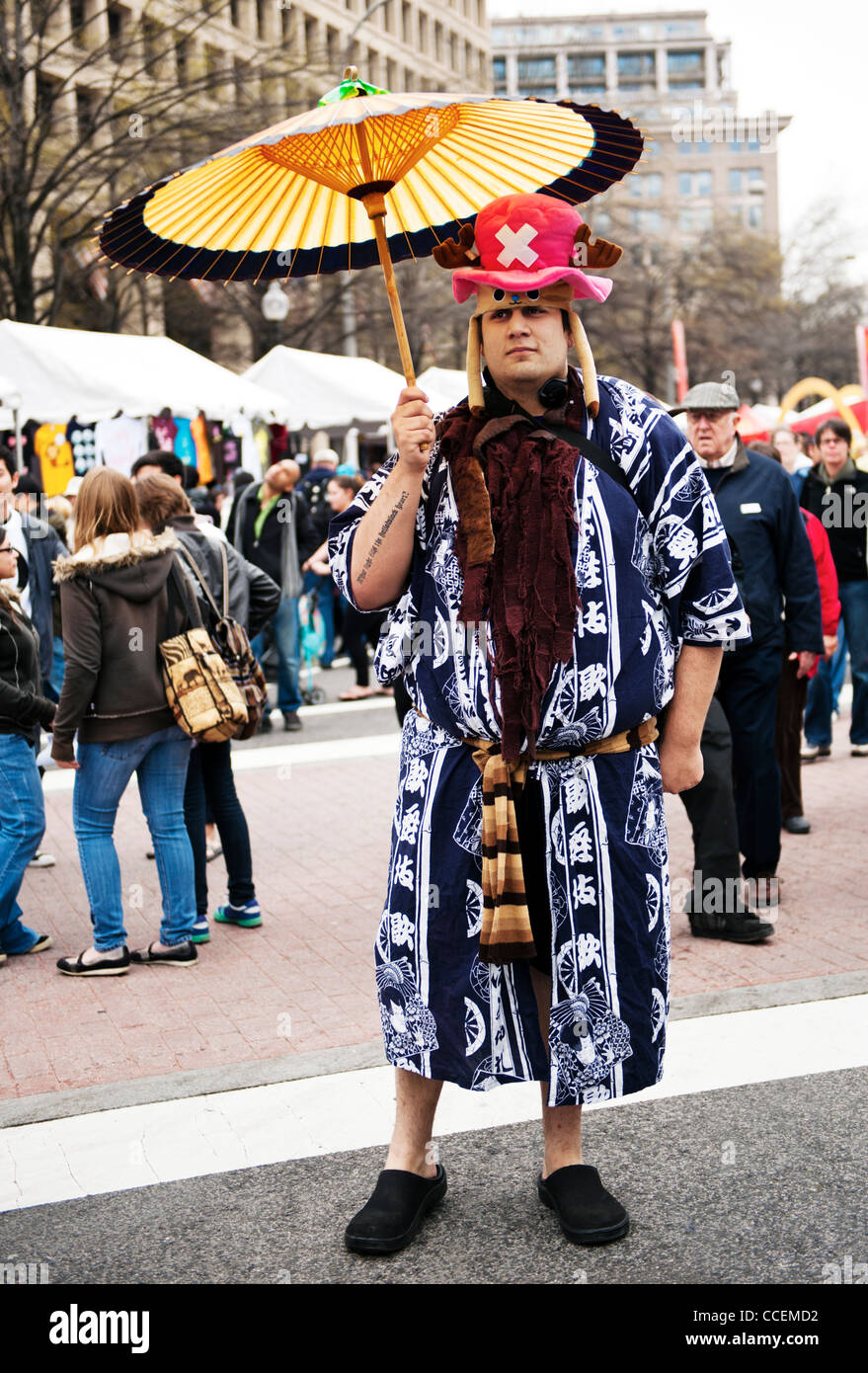 Un uomo vestito con un abito con un buffo cappello e Ombrello giapponese Sakura Matsura un giapponese street fair in Washington DC Foto Stock