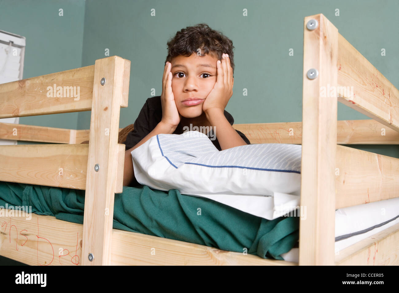 Stanco multi etnico ragazzo disteso sul letto Foto Stock