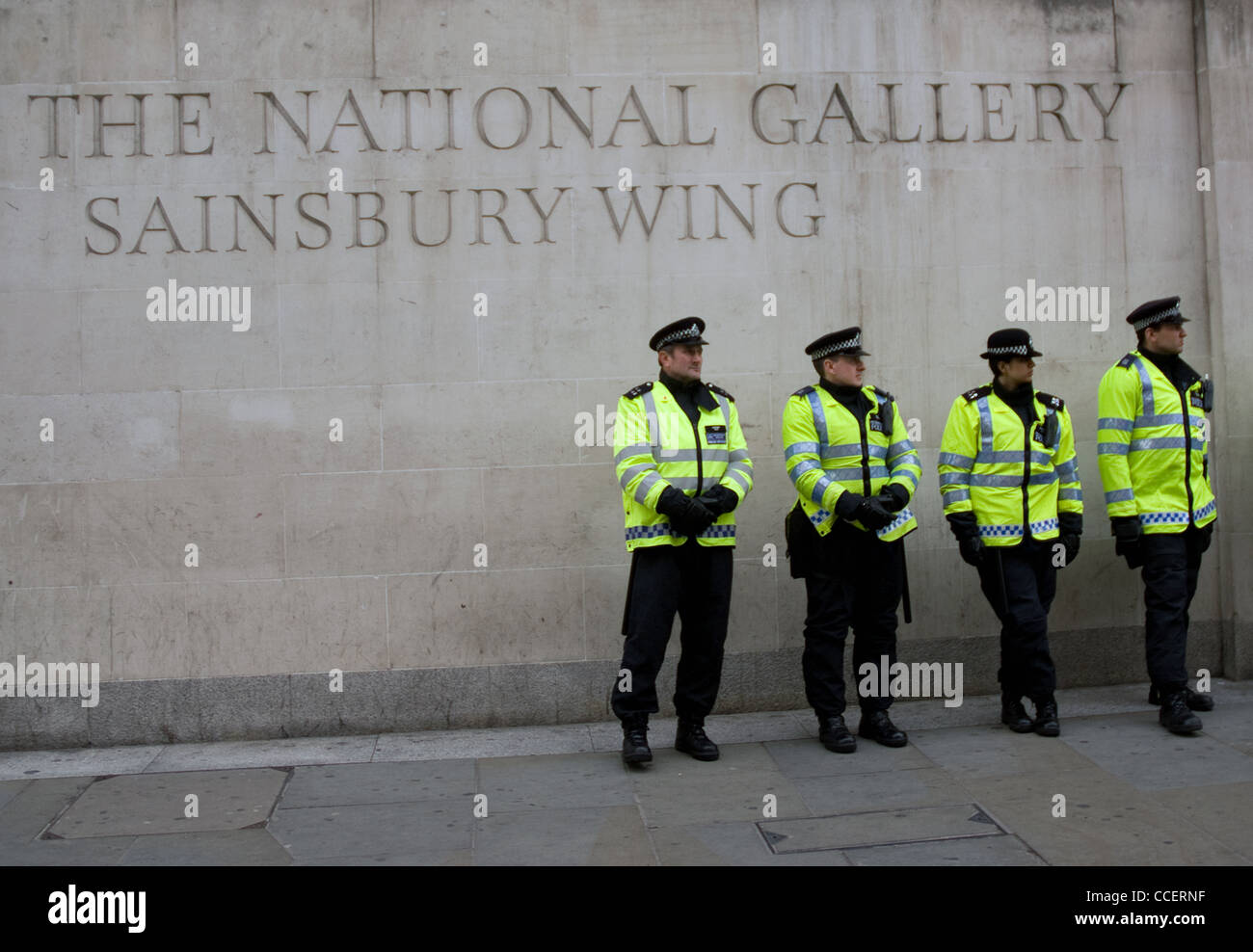 La polizia di uomini e donne in piedi al di fuori della galleria nazionale durate mantenendo un sui manifestanti a Trafalgar Square Foto Stock