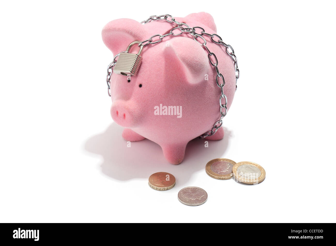 Una catena e bloccato salvadanaio con British monete accanto ad esso Foto Stock