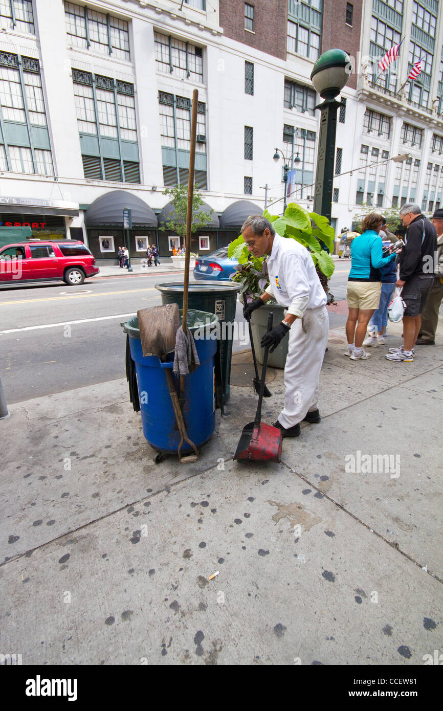 Uomo che pulisce il marciapiede in New York City - Scene di strada Foto Stock