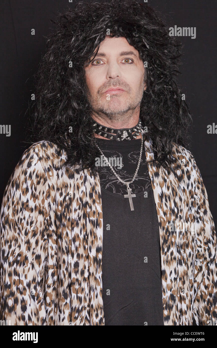 Ritratto di uomo di mezza età che indossa a pelle di leopardo pattern su sfondo nero Foto Stock