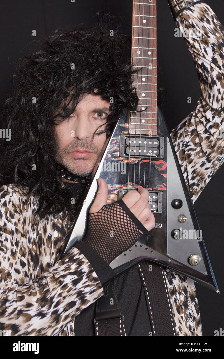 Ritratto di uomo di mezza età che indossa a pelle di leopardo pattern con chitarra elettrica Foto Stock