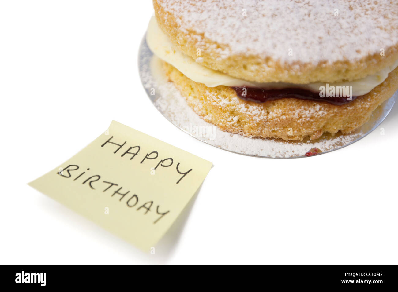 Deliziosa torta fetta con "happy birthday" notepaper Foto Stock
