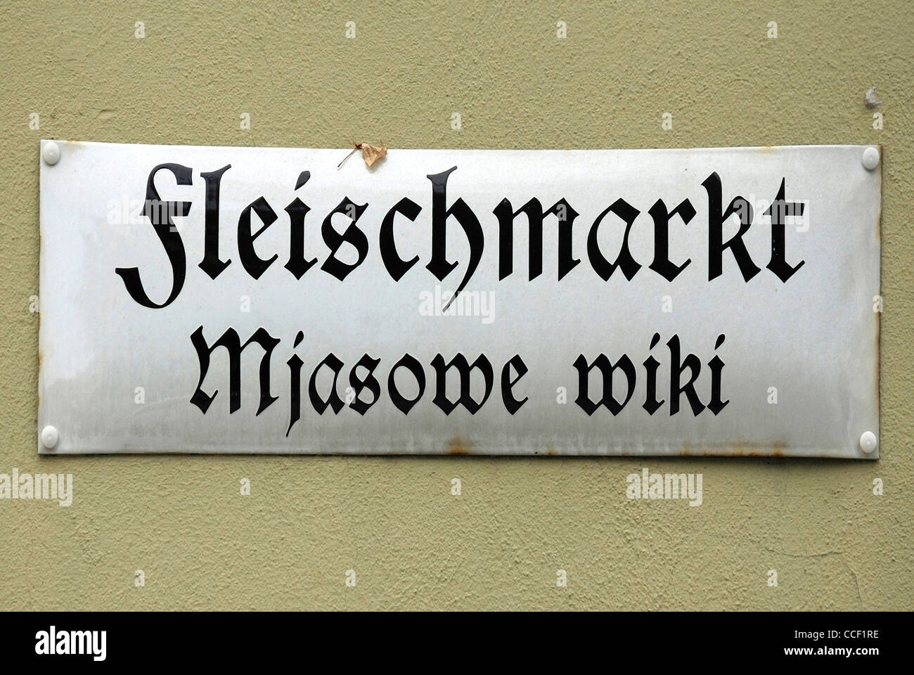 Un cartello stradale di Bautzen in tedesco e sorabo lingua in Fleischmarkt - Mjasowe wiki. Foto Stock