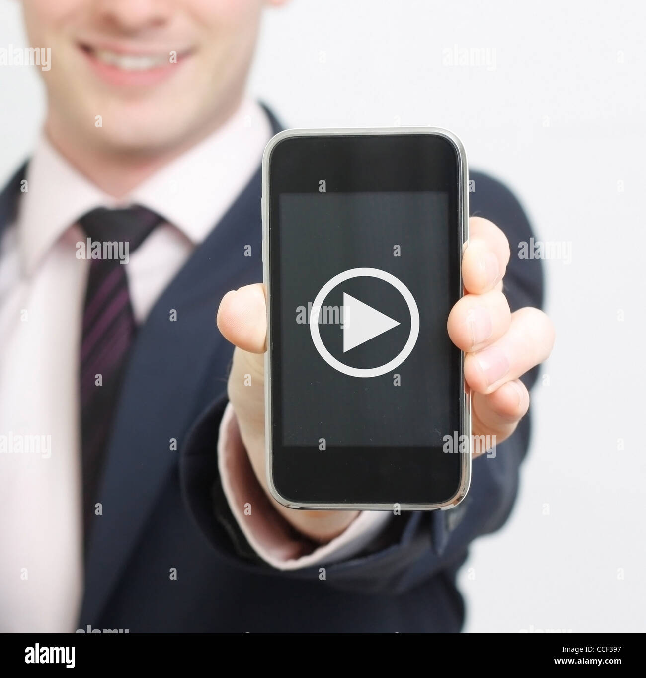 Un uomo di affari che mostra il suo telefono con pulsante video Foto Stock