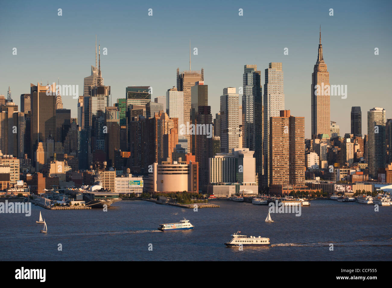 Barche a vela e i traghetti sul fiume Hudson con il Midtown skyline di Manhattan in background Foto Stock