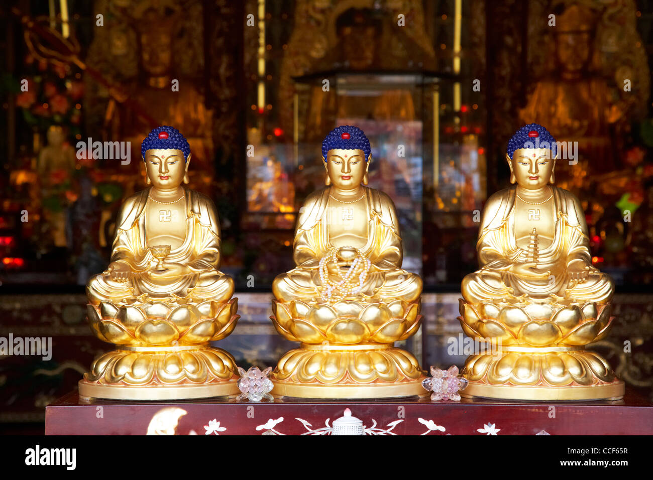 Fila di tre piccoli Golden Statue di Buddha nel monastero di diecimila buddha sha tin nuovi territori di Hong kong RAS di Hong kong cina asia Foto Stock