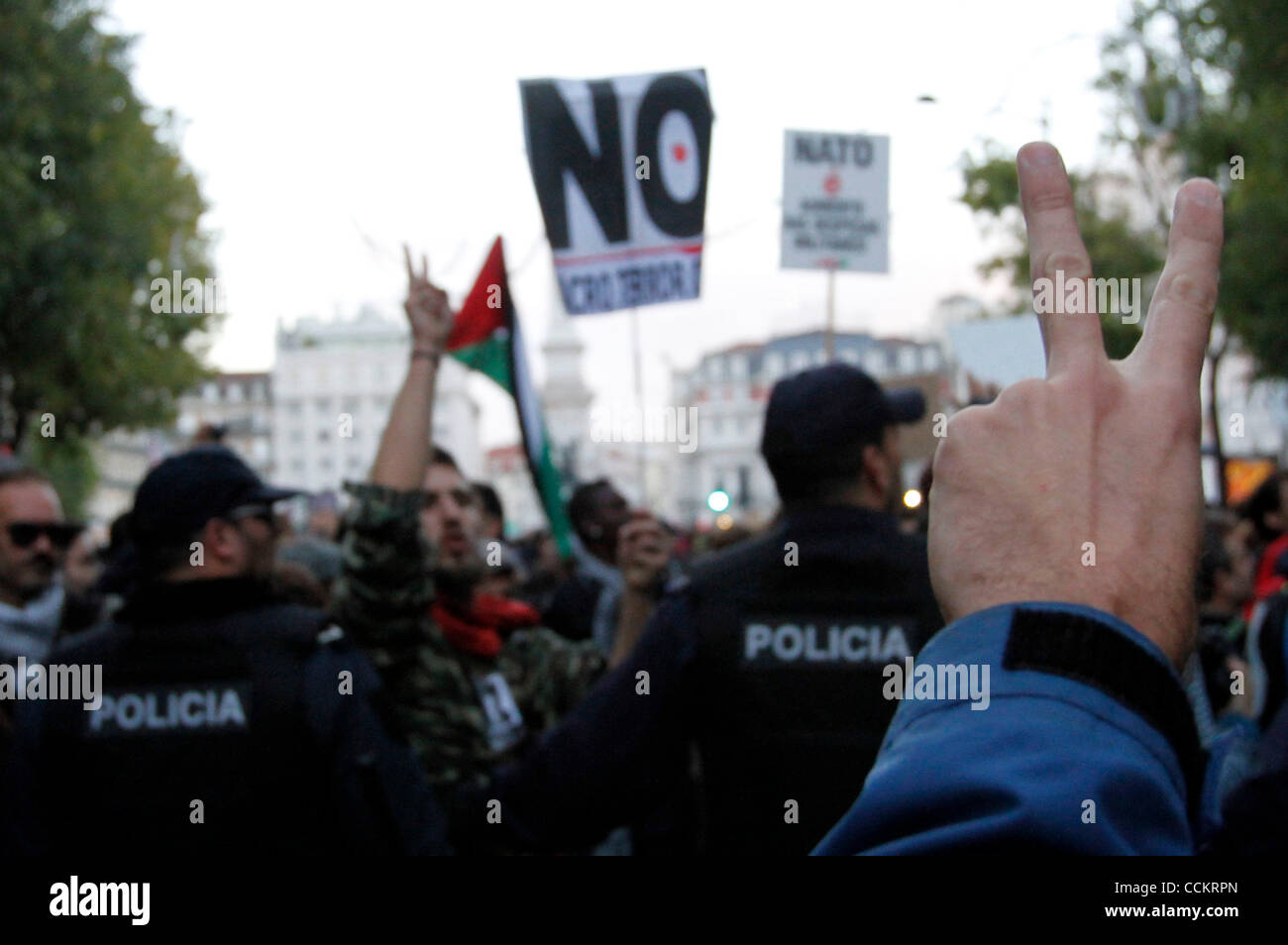 20 nov 2010 - Lisbona, Portogallo - Anti-NATO di uomo che fa il gesto di pace durante una manifestazione di protesta contro il vertice della NATO a Lisbona il 20 novembre 2010. Il vertice della NATO è tenuta a Lisbona, durante il diciannovesimo e il ventesimo giorno di novembre. Si tratta di una riunione con 27 leader dell Unione europea e membri della NATO, che discuterà la centra Foto Stock