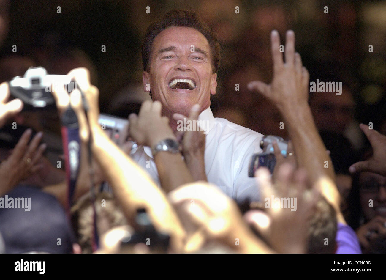 Il governatore della California Arnold Schwarzenegger sorrisi come egli getta t-shirt a tifosi durante un "cittadini rally' a Sherwood Mall in Stockton, CA domenica 18 luglio, 2004. Il governatore ha esortato i presenti a contattare i legislatori e dire loro di sostenere il governatore di bilancio. (Sacramento B Foto Stock