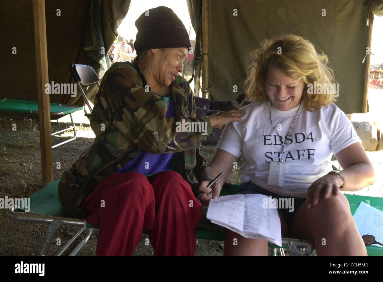 Air Force veterano Brenda Parchi di San Francisco scherzi con volontario Janette Licata (CQ) di Oakland come essi registrati parchi e decidere quale tipo di abbigliamento vuole ordine sulla forma durante la East Bay Stand giù a Camp parchi, giovedì, 12 agosto 2004, a Dublino, Calif. Oltre 360 senzatetto veterani Foto Stock