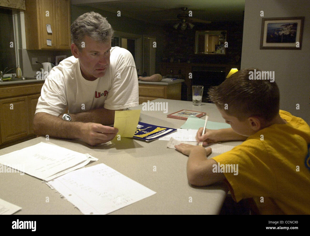 Andy Alkire quiz uno dei suoi tre figli Sean, 9, con alcune parole di ortografia ha bisogno di imparare per la sua elementare Strandwood quarta classe di grado A 7:52 pm in casa loro a Pleasant Hill, California, giovedì 16 settembre, 2004. (EDDIE LEDESMA/volte) Foto Stock