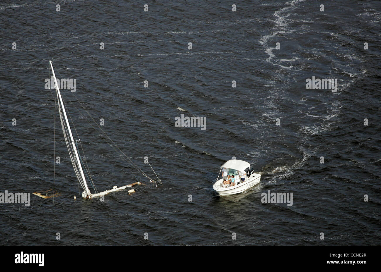 092604 hur ae- un motoscafo controlla una barca a vela affondata nel lago di Peck (parte della Intracoastal Waterway a Hobe Sound) dopo l uragano Jeanne. Foto personale Eyestone Allen. Foto Stock