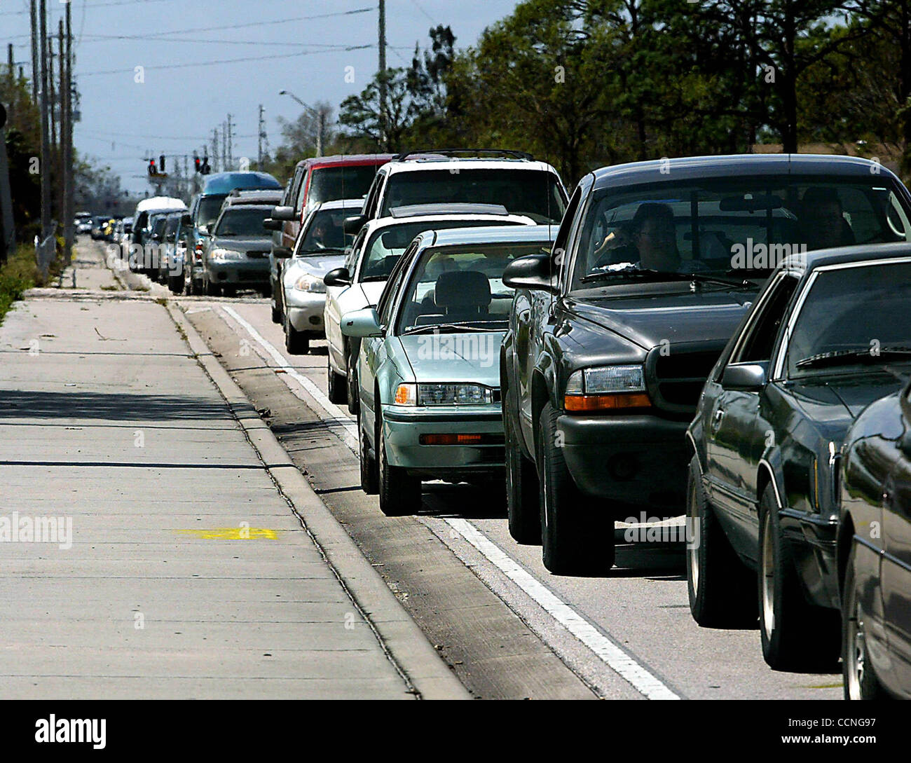 101004-Fort Pierce-Vehicles allineati in direzione est sulla strada di Edwards per immettere la Twin Vee barche di parcheggio per le forniture gratuite e un pasto caldo domenica. Twin Vee barche, il St. Lucie County Explorer Post 400 e l'Isola del Tesoro (vicino a San Pietroburgo) i membri della Comunità sono stati tra i volontari di questo uragano Foto Stock