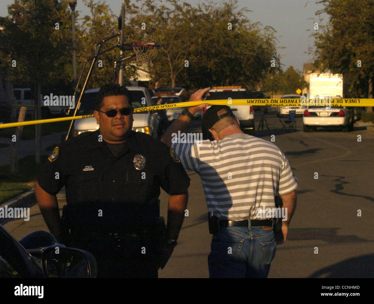 Brentwood funzionario di polizia Sergio Verbis (CQ)(a sinistra) guarda mentre Brentwood Lt. Brian Strock fa il suo modo di una scena del crimine su Ford Street vicino a Hudson Drive in un solitamente nel tranquillo quartiere di Brentwood, California il Sabato, Ottobre 16, 2004. (Dean Coppola / Contra Costa Times) Foto Stock