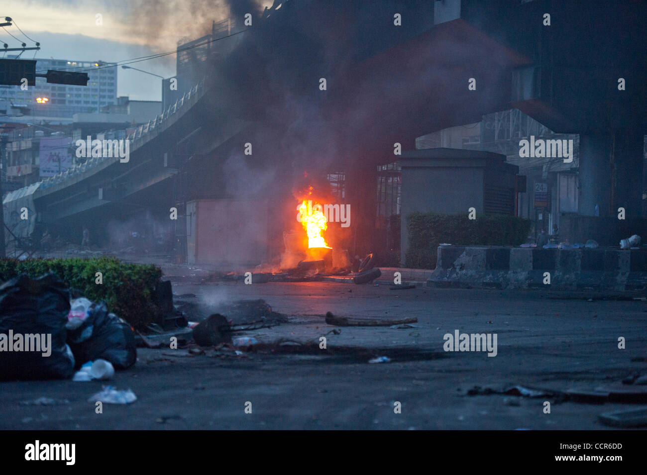 Camicie Rosse manifestanti bruciano pneumatici per creare cortina di fumo a Din Daeng intersezione. Barricate dei pneumatici sono state inoltre istituito intorno Din Daeng intersezione da Camicie Rosse i manifestanti come intersezione è stato sotto il fuoco da sniper nascondere nel vicino edificio. Camicie rosse si sono scontrati con Thai securi Foto Stock