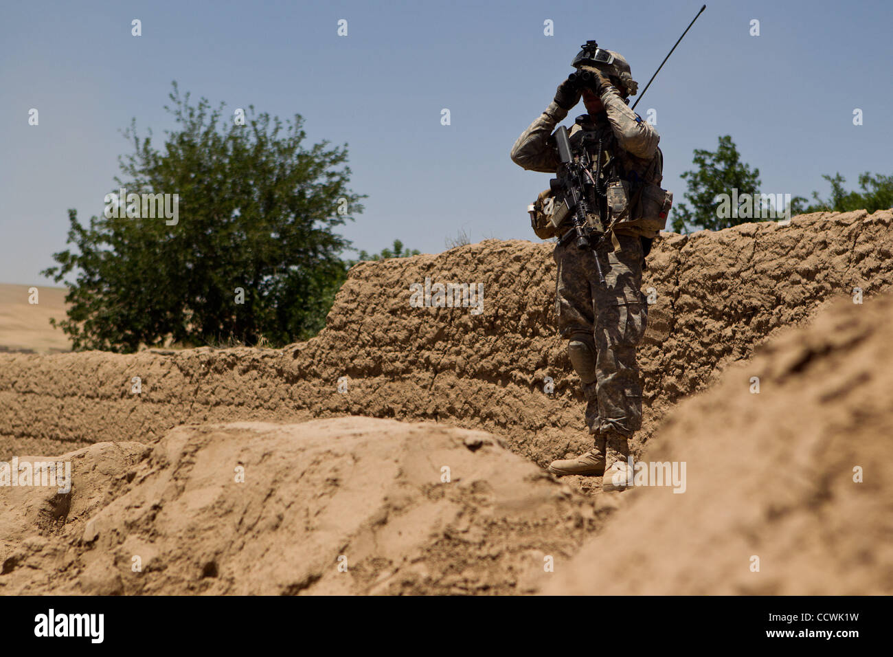 18 maggio 2010 - Provincia di Herat, Afghanistan - STATI UNITI Army Sgt. Joshua Hampson della sede centrale e sede Battery Company, 2° Battaglione, campo 321artiglieria, quarta brigata Team di combattimento, ottantaduesima Airborne Division, orologi per un movimento mentre il pattugliamento un villaggio nel distretto di Kushk della provincia di Herat, Foto Stock