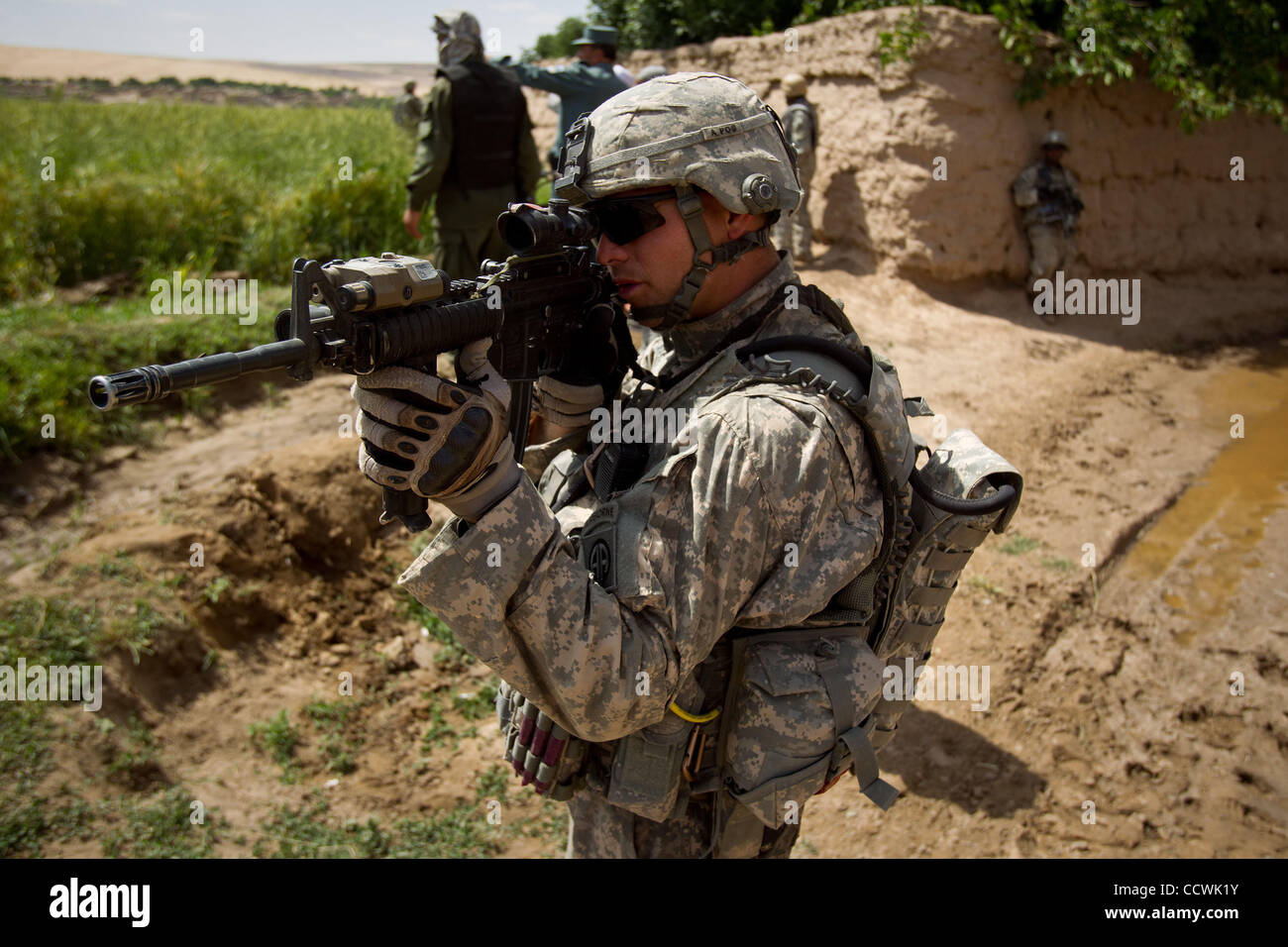 18 maggio 2010 - Provincia di Herat, Afghanistan - STATI UNITI Esercito Cpt. Aron Hauquitz, della sede centrale e sede Battery Company, 2° Battaglione, campo 321artiglieria, quarta brigata Team di combattimento, ottantaduesima Airborne Division, utilizza il suo fucile della possibilità di osservare il movimento distante mentre pattugliano un villaggio di Kush Foto Stock