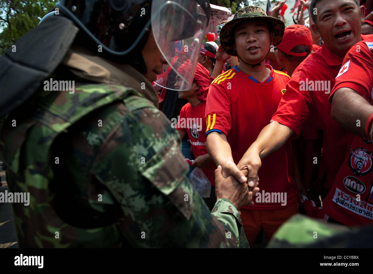 Mar 27, 2010 - Bangkok, Thailandia - Thai Soldato Antisommossa marcia stringono le mani con anti-governo manifestanti che lasciano i motivi del tempio buddista in prossimità del Palazzo del Governo. Governo anti-manifestanti sono stati il tifo e gridare parole di ringraziamento per l'esercito come soldati l Foto Stock