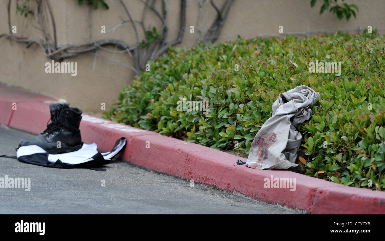 10 maggio 2010 - Corona, California, Stati Uniti - Una sanguinosa camicia, bullet proof vest, e un paio di scarpe si siede in strada dove un auto blindata guardia è stata trattata per una ferita gunshot dopo un portavalori rapina in banca d'America in Norco. Autorità erano alla ricerca di tre rapine a mano armata contro i sospetti su MO Foto Stock