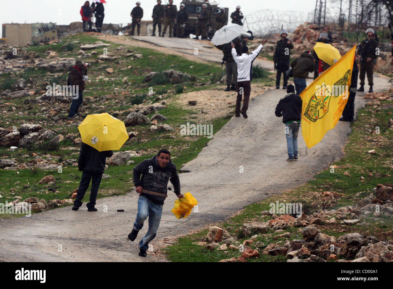 Sildiers israeliano fire le scatole metalliche del gas lacrimogeno verso i dimostranti palestinesi durante una manifestazione di protesta nel villaggio di Bilin nel Febbraio 4, 2011. Foto di Issam Rimawi Foto Stock