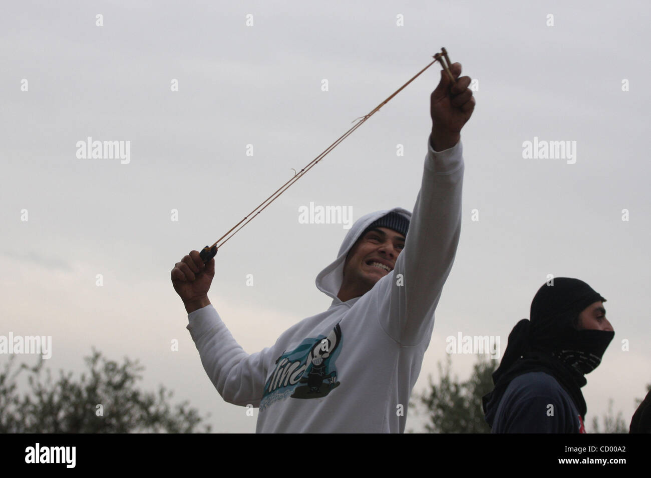Una gioventù palestinese Scaglia Pietre verso sildiers israeliano durante una manifestazione di protesta nel villaggio di Bilin vicino a Ramallah nel Febbraio 4, 2011. Foto di Issam Rimawi Foto Stock