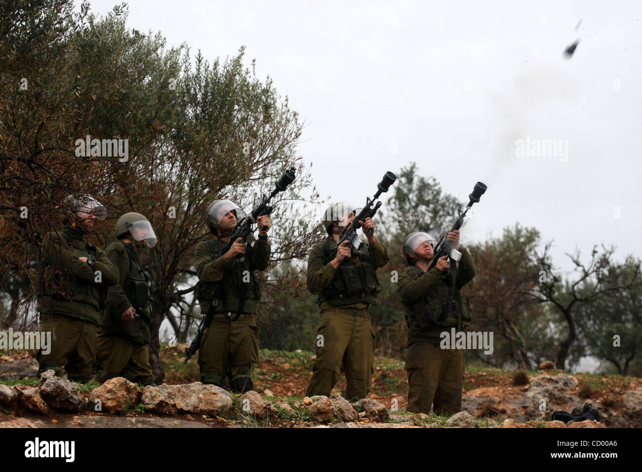 Sildiers israeliano fire le scatole metalliche del gas lacrimogeno verso i dimostranti palestinesi durante una manifestazione di protesta nel villaggio di Bilin nel Febbraio 4, 2011. Foto di Issam Rimawi Foto Stock