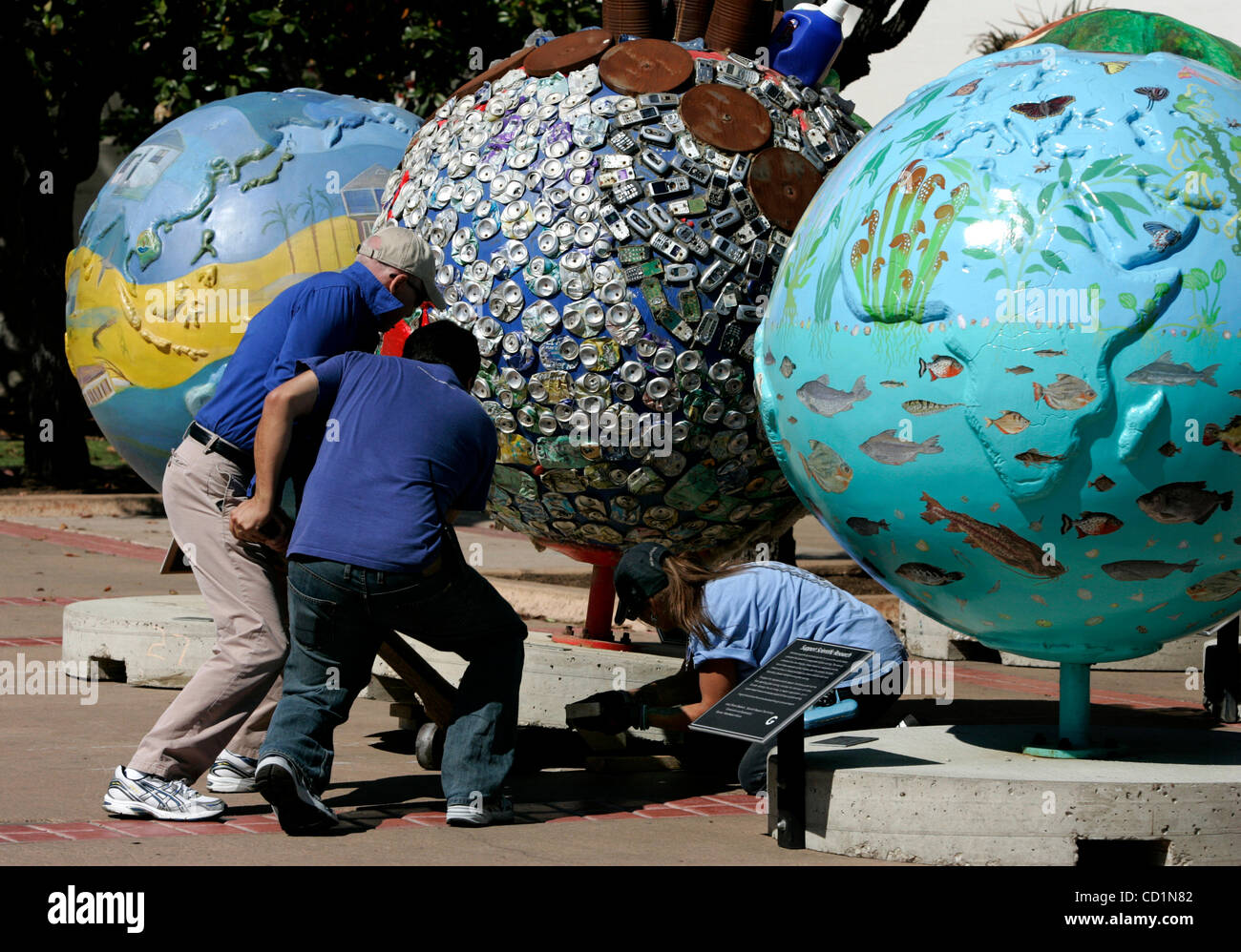 Ottobre 16, 2008 San Diego, CA ROBERT LYNVILLE, di San Diego Natural History Museum visitor services department, sinistra, FAUSTO CASTILLO di servizi per i visitatori, centro e LAURA MASOTTI, presentano il tecnico, destra, installare uno dei 42 "Cool globi,' al di fuori di San Diego il Museo di Storia Naturale. Il glob Foto Stock