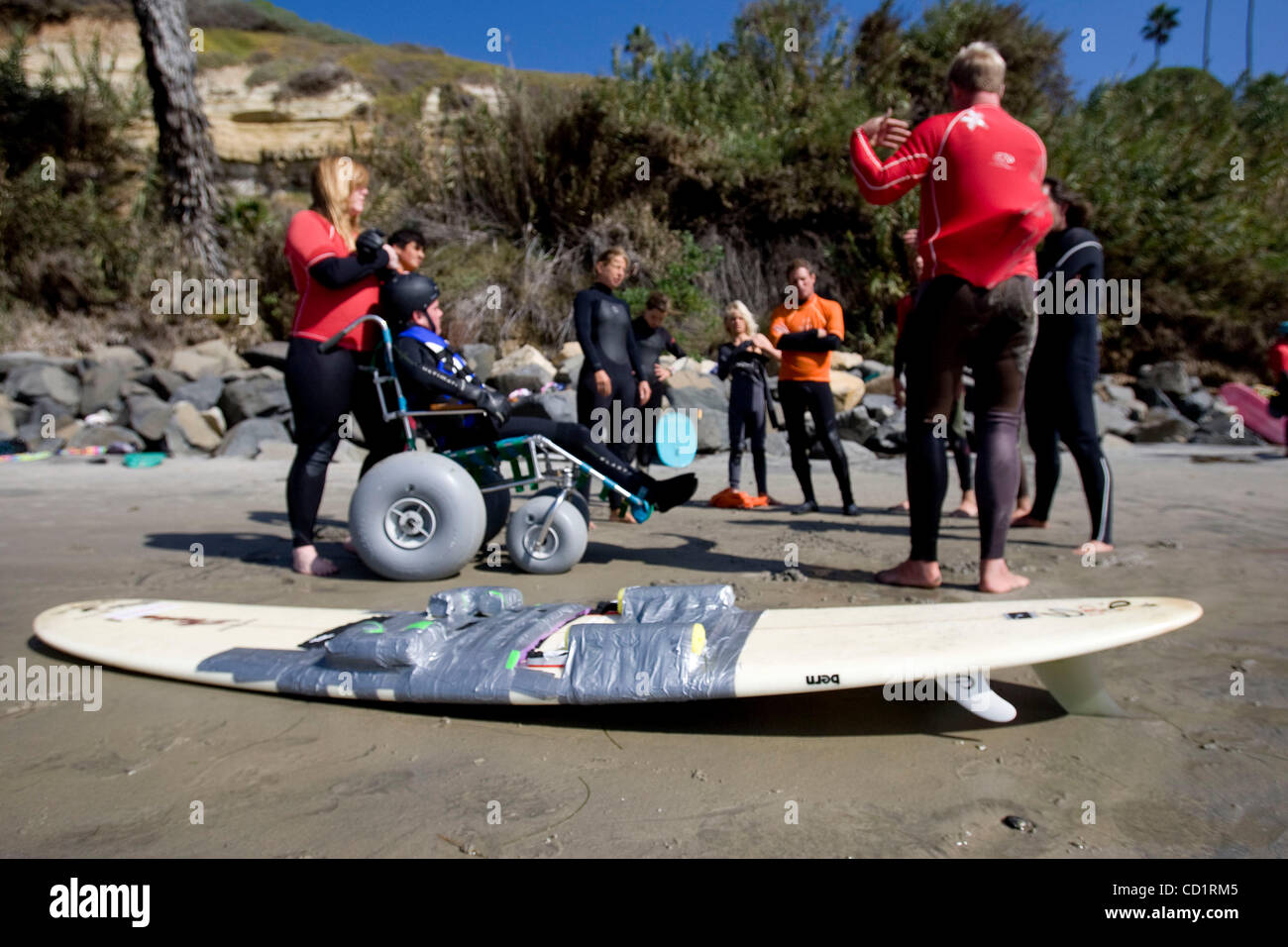Ottobre 26, 2008 Encinitas California USA  (sul lato destro del telaio, Parte superiore rossa e il braccio sinistro verso l'alto) Robbie Nelson (proprietario di felice di barili di lezioni di Surf & persona responsabile per mettere insieme Patrizio escursioni surf) parla con i volontari circa il processo di getting Patrick su alcune onde. In foregr Foto Stock