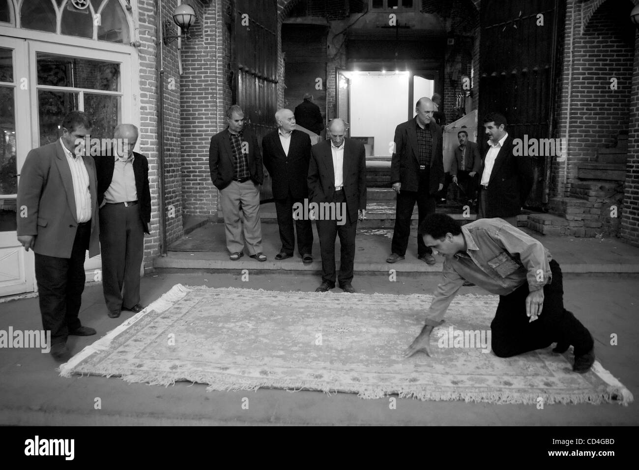 Ottobre 07, 2008 - Tabriz, Iran - i clienti di analizzare un tappeto in Mozaffariye sub-bazar. Il bazar di Tabriz è uno dei più antichi bazar del Medio Oriente e il più grande bazar coperto nel mondo. Esso è stato iscritto come sito del patrimonio mondiale dall UNESCO nel luglio 2010. Situato nel centro della città di T Foto Stock