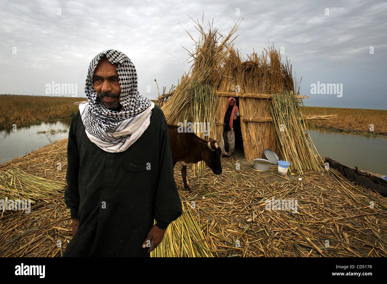 Ottobre 29, 2008 - Al Hamar Marsh, Iraq - Due uomini a piedi da una tradizionale dimora di palude. Alcuni marsh Ahrabs sono la costruzione di casa con il più moderno blocco e mortaio...La palude gli arabi sono stati costretti a lasciare la loro terra natia dopo la loro paludi furono scolati e solo poche migliaia di quasi mezzo milione di ettari Foto Stock