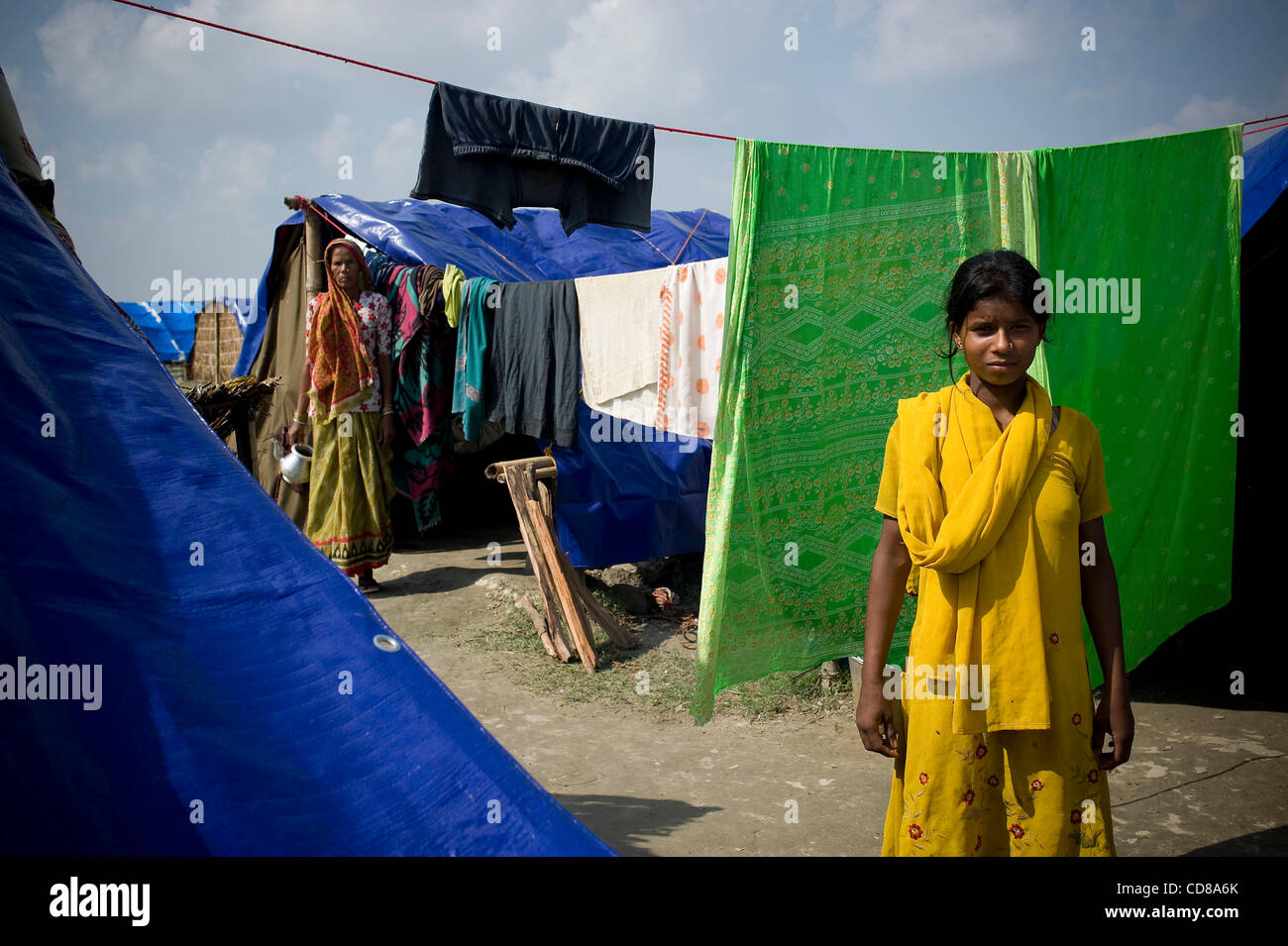 I colori vivaci intorno a lei non porta allegria a Sabnam Khatun, 12. In entrambi Saptari e Sunsari distretti in Nepal, Koshi rifugiati lotta contro gli elementi in rifugi temporanei , fatta di telone e qualunque esse possono trovare. Foto Stock