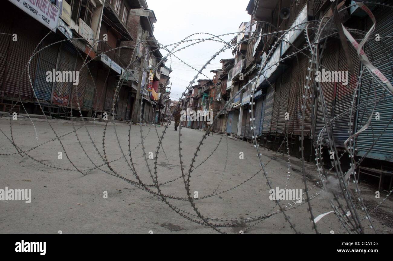 Jul 31, 2010 - Srinagar Kashmir, India - polizia pattuglia vicino al filo spinato durante un coprifuoco. Un adolescente è stato ucciso e sei persone sono rimaste ferite in Indiana forza di sicurezza la cottura con il proseguire delle violenze nel nord del Kashmir del distretto di Baramulla, 60 km da Srinagar. Le autorità istituite cur Foto Stock