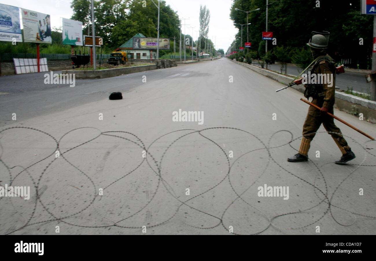Jul 31, 2010 - Srinagar Kashmir, India - polizia pattuglia vicino al filo spinato durante un coprifuoco. Un adolescente è stato ucciso e sei persone sono rimaste ferite in Indiana forza di sicurezza la cottura con il proseguire delle violenze nel nord del Kashmir del distretto di Baramulla, 60 km da Srinagar. Le autorità istituite cur Foto Stock