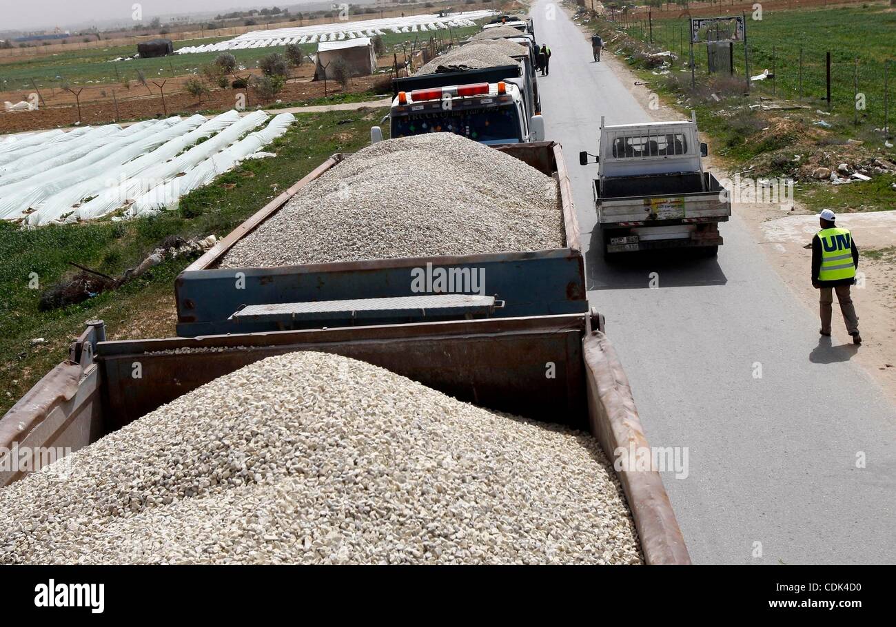 Mar 09, 2011 - Rafah nella striscia di Gaza - lavoratori dall'Ente soccorso e lavori delle Nazioni Unite (UNRWA) sorvegliare i carrelli caricati con ghiaia presso l' attrice in via principale di frontiera con Israele. Israele ghiaia ammessi per l'Ente soccorso e lavori delle Nazioni Unite per i profughi della Palestina (UNRWA), per la prima volta dal Foto Stock