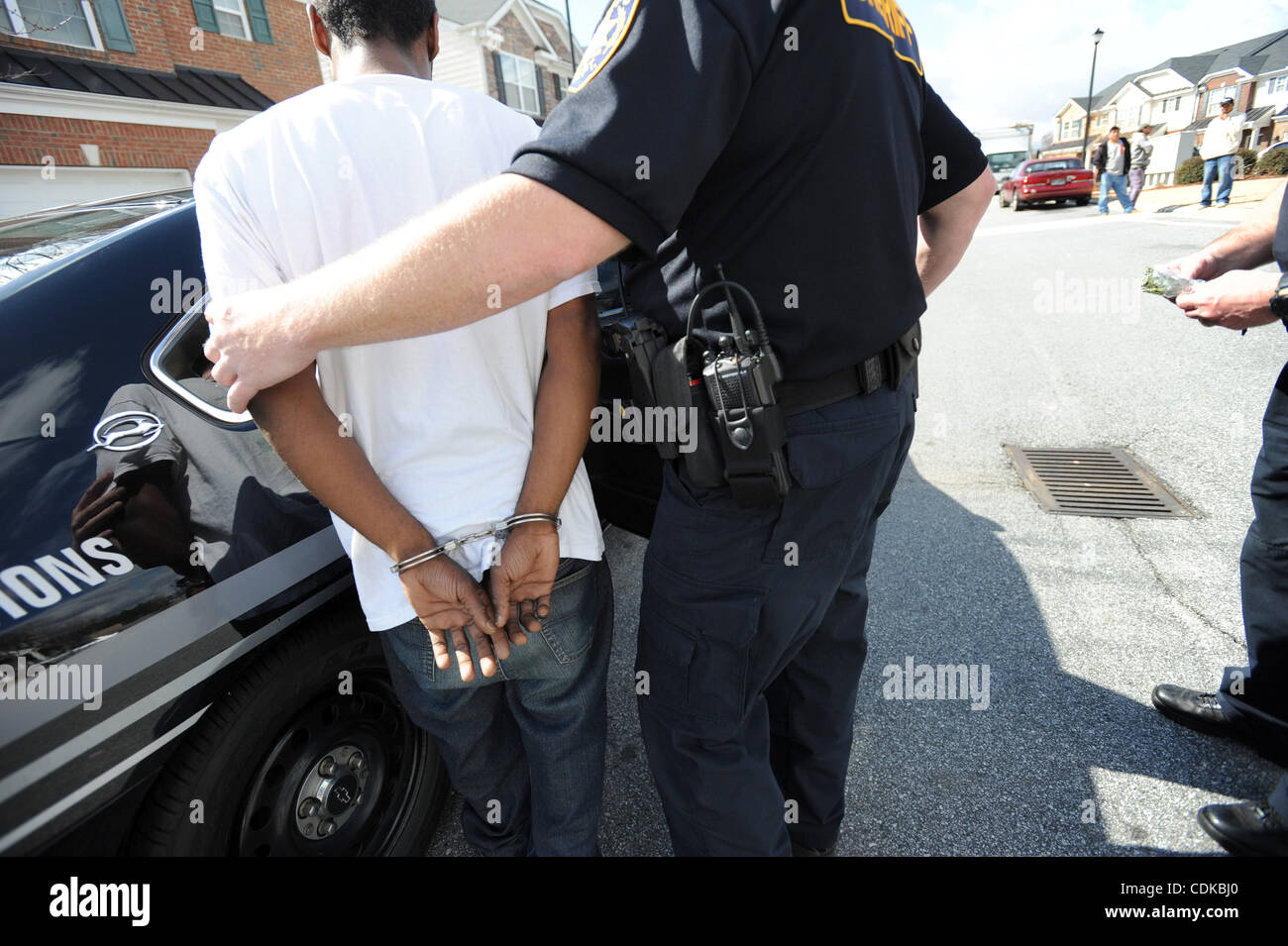 Mar 15, 2011 - Norcross, Georgia, Stati Uniti - Il Vice T. Wigenton (R) con la Gwinnett County Sheriff ufficio del tribunale civile di divisione, accompagnatrici resident Maurice Adams dopo il suo arresto per presunto avente un eccezionale garantisce e possesso di marijuana, mentre si serve di un sfratti in Norcross, Georgia USA Foto Stock